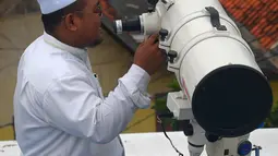 Petugas memeriksa teropong yang digunakan untuk melihat posisi hilal (bulan) dari Pondok Pesanteren Al-Hidayah Jakarta, Selasa (15/5). (Merdeka.com/Imam Buhori)