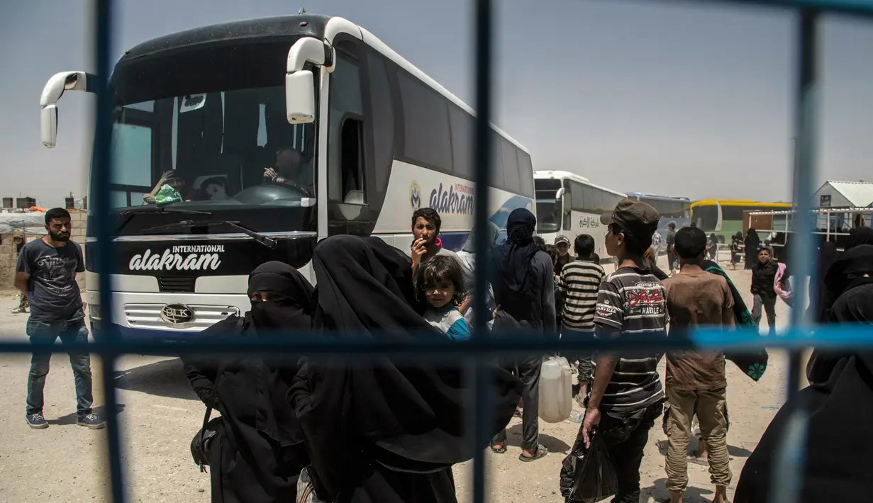 Perempuan dan anak-anak keluarga militan ISIS bersiap meninggalkan kamp penampungan al-Hol di Provinsi Hasakeh, Suriah, Senin (3/6/2019). Para perempuan dan anak-anak dibebaskan menggunakan bus dan truk. (AP Photo/Baderkhan Ahmad)
