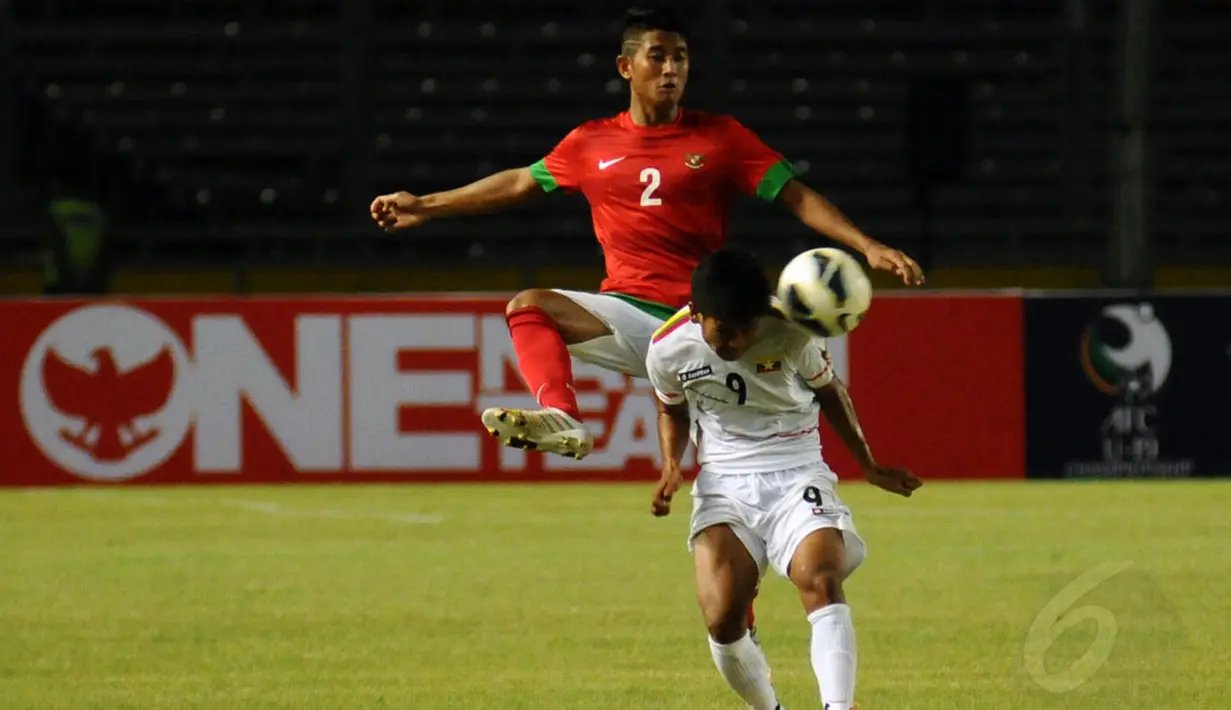 Bek Timnas Indonesia U-19, Putu Gede Juni Antara (atas) mencoba menahan laju serangan pemain Myanmar, Aung Thu, saat berlaga di Stadion GBK Jakarta, (5/5/2014). (Liputan6.com/Helmi Fithriansyah)