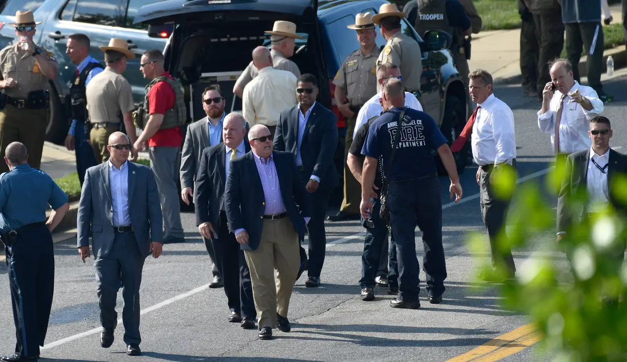 Gubernur Maryland, Larry Hogan (tengah) mendatangi lokasi penembakan brutal di kantor surat kabar lokal di Annapolis, AS, Kamis (28/6). Hogan menyampaikan duka atas tragedi yang terjadi di gedung Capital Gazette. (AP/Susan Walsh)