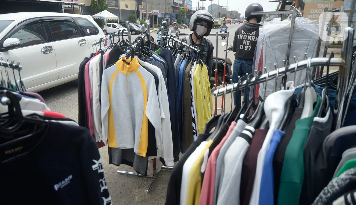 Pembeli sedang memilih baju seken (baju bekas) impor di pingir jalan wilayah Pamulang, Tangerang Selatan, Banten, Senin (29/9/2020). Pada saat pandemi baju bekas impor masih diminati masyarakat karena murah harganya. (merdeka.com/Dwi Narwoko)