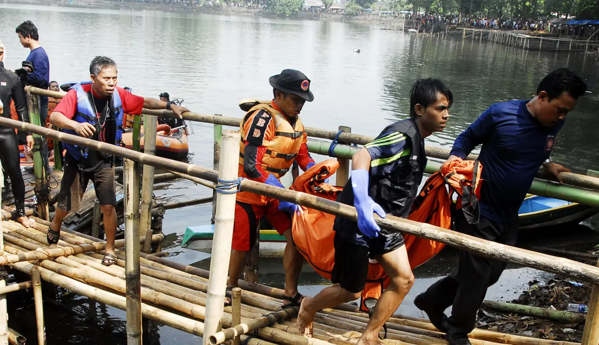 Tim penyelamat mengangkat jenazah salah satu korban perahu tenggelam di Setu Cikaret, Cibinong, Bogor, Jabar, (4/8/2014). (ANTARA FOTO/Jafkhairi)