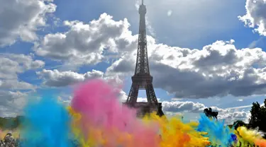 Bermacam serbuk warna bertebaran saat acara Color Run 2017 di depan Menara Eiffel, Paris, Minggu (16/4). Lomba lari sepanjang 5 km tanpa hadiah itu diikuti ribuan peserta. (AFP PHOTO / CHRISTOPHE ARCHAMBAULT)