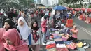 Warga melintasi lapak PKL saat car free day di MH Thamrin, Jakarta, Minggu (8/9/2019). Penutupan sebagian jalan akibat proyek revitalisasi trotoar membuat para PKL menggelar lapak hingga ke badan jalan sehingga menyebabkan aktivitas olahraga warga terhambat. (merdeka.com/Iqbal S. Nugroho)