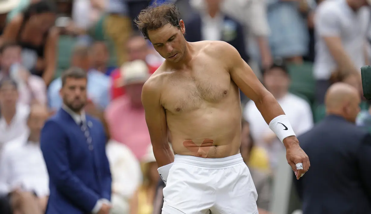 Namun keesokan harinya, Kamis (7/7/2022) Rafael Nadal merasakan kondisi cedera di perutnya kembali kambuh saat melakukan latihan. Setelah pemeriksaan lebih lanjut, diketahui ia mengalami robek otot perut sepanjang 7 mm. Tak ingin kondisinya bertambah parah, ia pun memutuskan mundur dari laga semifinal menghadapi Nick Kyrgios. (AP/Kirsty Wigglesworth)