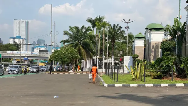Nampak petugas kebersihan membersihkan depan gerbang Gedung DPR RI usai demonstrasi penolakan RUU Kesehatan pada Selasa, 11 Juli 2023.