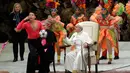 Seorang anggota kelompok sirkus Kuba memberi isyarat kepada para hadirin untuk menonton ketika dia meminta Paus Fransiskus untuk memutar bola di jari saat audiensi umum mingguan di Vatikan, Rabu (2/1). (AP Photo/Andrew Medichini)