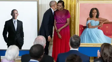 Mantan Presiden AS Barack Obama mencim istrinya, mantan ibu negara Michelle Obama setelah meresmikan lukisan mereka yang akan menjadi koleksi Gedung Putih di Ruang Timur Gedung Putih, Washington, Rabu (7/9/2022). Kedua gambar itu merupakan karya Robert McCurdy dan terlihat lebih seperti potret. (AP Photo/Andrew Harnik)