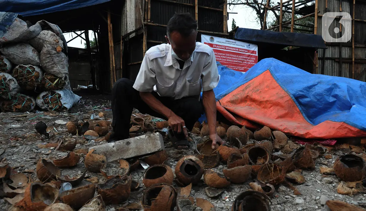 Andi (52), pembuat arang batok kelapa yang usahanya ditutup sementara oleh Pemerintah Kota Jakarta Timur di Kawasan Lubang Buaya, Selasa (29/9/2023). (merdeka.com/Imam Buhori)