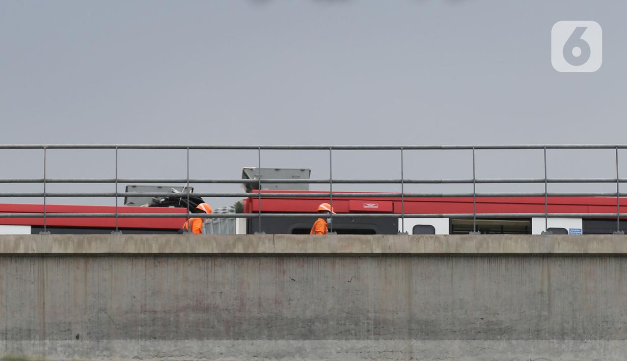 Petugas melakukan persiapan evakuasi kereta LRT yang kecelakaan di ruas Cibubur, Jakarta, Jumat (29/10/2021). PT INKA akan berkoordinasi dengan Jasa Marga selaku pengelola Jalan Tol Jagorawi dan Kepolisian untuk pengaturan lalu lintas guna mendukung proses evakuasi. (Liputan6.com/Herman Zakharia)