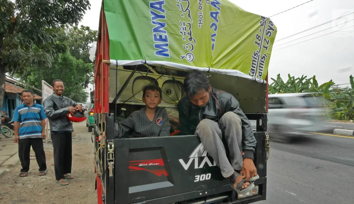 Pemudik bersama keluarganya menggunakan motor bak roda tiga bersiap kembali melakukan perjalanan mudik di Jalur Pantura kawasan Pemalang, Jawa Tengah, Senin (3/6/2019). Keluarga ini menuju kampung halamannya di Banjarnegara, Jawa Tengah. (Liputan6.com/Herman Zakharia)