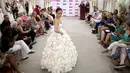 Model berjalan mengenakan 'Garden Party' karya Carol Touchstone saat kontes gaun pengantin yang terbuat dari tisu toilet di Butik Kleinfled's Bridal, New York, 17 Juni 2015. (REUTERS/Brendan McDermid)