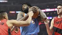 Center Los Angeles Clippers DeAndre Jordan (tengah) mengamankan bola dari kepungan pemain Portland Trail Blazers pada laga NBA di Staples Center, Minggu (18/3/2018) atau Senin (19/3/2018) WIB. (AP Photo/Michael Owen Baker)