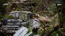 Seorang wanita mencari barang-barang miliknya setelah rumahnya hancur dihantam tornado di Regla, Kuba (28/1). Tornado dan hujan deras menghantam Bagian timur ibukota Kuba. (AP Photo/Ramon Espinosa)
