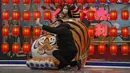Pasangan berswafoto dengan hiasan harimau di sebuah pusat perbelanjaan di Beijing, Minggu (9/1/2022). Tianjin memulai pengujian massal terhadap 14 juta penduduknya setelah sekelompok anak-anak dan orang dewasa dinyatakan positif COVID-19, beberapa dengan varian omicron. (AP Photo/Andy Wong)