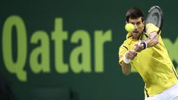 Petenis Serbia, Novak Djokovic, memukul bola ke arah area lapangan pemain Argentina, Leonardo Mayer, dalam turnamen tenis Qatar Terbuka 2016 di Doha, Qatar, (7/1/2016). (AFP/Karim Jaafar)