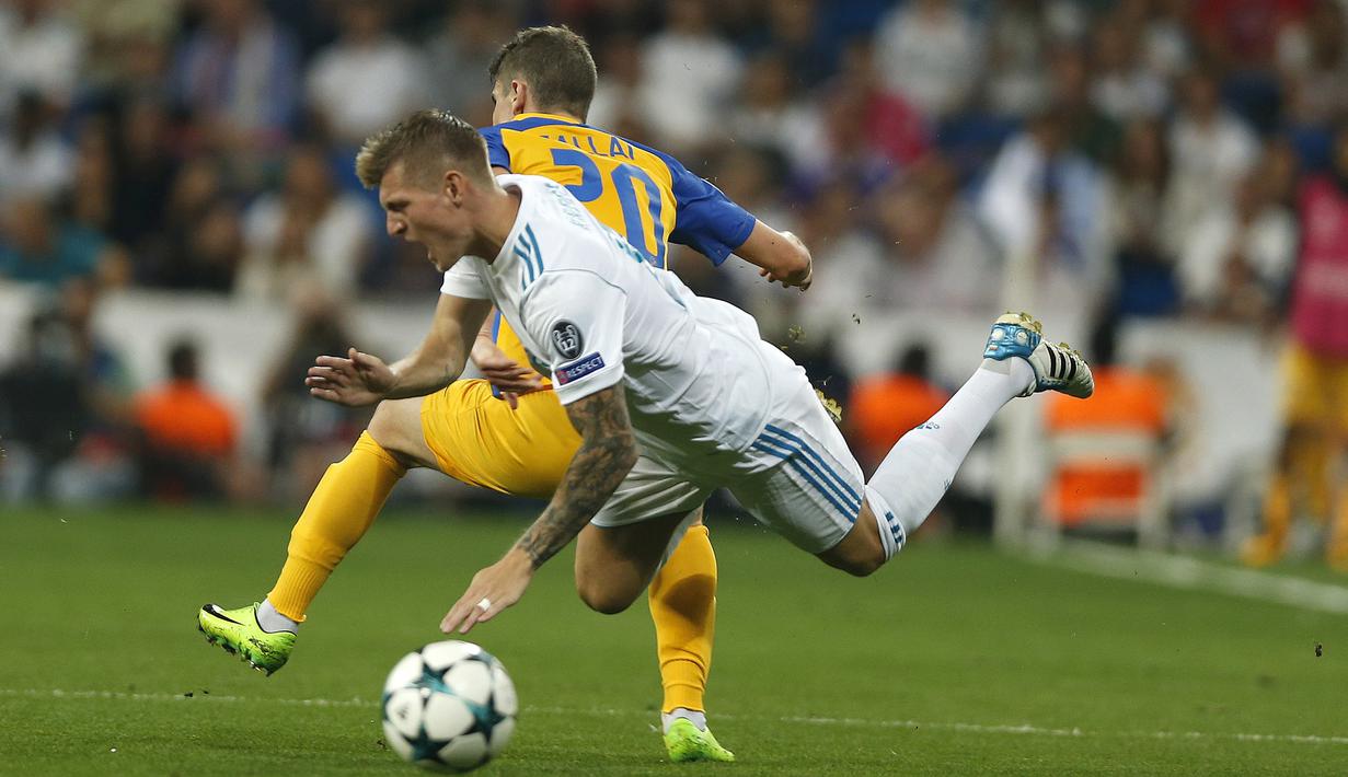 Pemain Real Madrid, Toni Kroos jatuh saat berebut bola dengan pemain APOEL Nicosia, Roland Sallai pada laga grup H Liga Champions di Santiago Bernabeu stadium, Madrid, (13/9/2017). Real Madrid Menang 3-0. (AP/Francisco Seco)