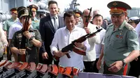 Presiden Filipina Rodrigo Duterte memeriksa senapan serbu AK-47 di kapal Admiral Panteleyev di pelabuhan Metro Manila, Filipina (25/10). 5.000 senapan AK-74M Kalashnikov dari Rusia disumbangkan untuk pemerintahan Filipina. (AFP Photo/Robinson Ninal)