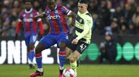 Gelandang Manchester City, Phil Foden berebut bola dengan pemain Crystal Palace, Tyrick Mitchell selama pertandingan lanjutan Liga Inggris di stadion Selhurst Park, di London, Minggu (12/3/2023). Hasil ini membuat Manchester City memangkas jarak dengan pemuncak klasemen sementara Premier League,Arsenal. City mengoleksi 61 poin, beda 2 angka dari Arsenal. (AP Photo/David Cliff)