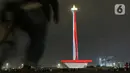 Suasana saat warga menyaksikan pertunjukan video mapping di Monumen Nasional (Monas), Jakarta, Minggu (22/12/2019). Acara ini berlangsung di pelataran barat Tugu Monas pada 22-31 Desember 2019. (Liputan6.com/Herman Zakharia)