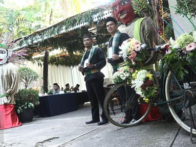 Petugas KPPS berbusana khas betawi menunggu warga yang akan menggunakan hak pilihnya pada pilkada DKI 2017 di TPS 03, Kelurahan Pulo, Jakarta Selatan, Rabu (19/4). Di TPS ini Wapres JusUf Kalla akan menyalurkan hak pilihnya. (Liputan6.com/Herman Zakharia)