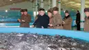 Pemimpin Korea Utara, Kim Jong Un mengunjungi Samchon Catfish Farm di Korea Utara, Selasa (21/2). Wajah Kim Jong Un terlihat bahagia saat melihat kolam yang penuh ikan lele. (AFP Photo/KCNA)