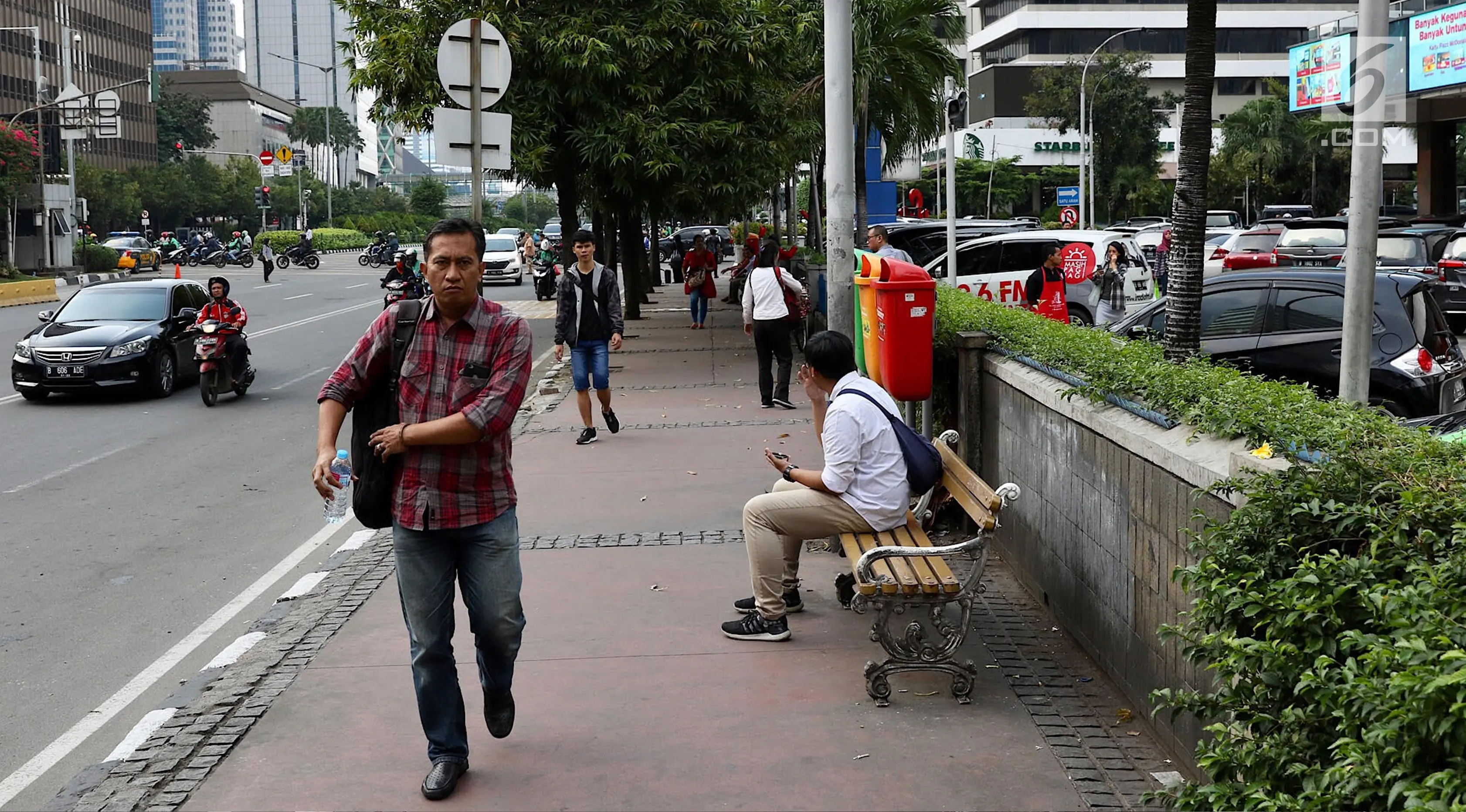 Pejalan kaki berjalan di trotoar kawasan MH Thamrin, Jakarta, Selasa (6/3). Penataan jalan dan trotoar kawasan Sudirman hingga MH Thamrin untuk mempersiapkan keindahan kawasan itu sebagai jalan protokol utama di Jakarta. (Liputan6.com/Immanuel Antonius)