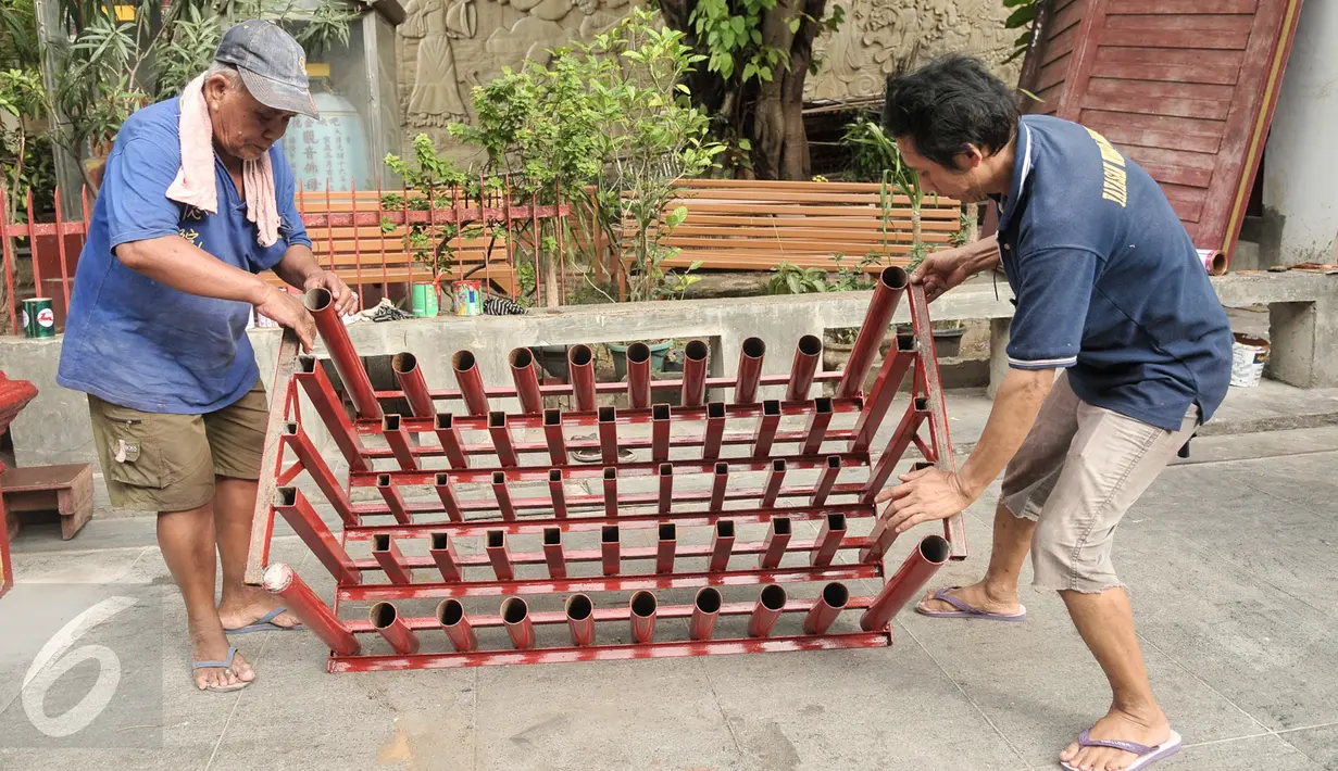 Petugas mempersiapkan tempat lilin di Vihara Dharma Bhakti Petak Sembilab, Jakarta, Senin (23/1). Jelang Imlek, Vihara Dharma Bhakti dipersiapkan dan dibersihkan untuk kenyamanan bersembahyang. (Liputan6.com/Yoppy Renato)