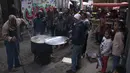 Warga mengantre untuk mendapatkan sup gratis yang dibagikan oleh Walid al-Hattab Palestina di Kota Gaza pada 24 Maret 2023. (AP Photo/Fatima Shbair)