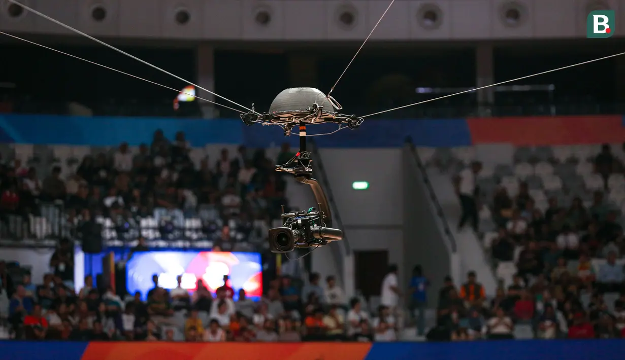 Spidercam saat merekam laga Piala Dunia FIBA 2023 antara Kanada melawan Lebanon di Indonesia Arena, Senayan, Jakarta, Minggu (27/08/2023). Jenis kamera ini ditempatkan di atas lapangan dan mampu bergerak fleksibel. Teknologi inilah yang membuat penonton mampu merasa lebih dekat dengan lapangan. (Bola.com/Bagaskara Lazuardi)