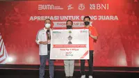 Dirut BNI, Royke Tumilaar (kiri), melakukan penyerahan simbolis dana pembinaan sebesar Rp5 miliar kepad Ketua PBSI, Agung Firman Sampurna (tengah) dan kapten tim Thomas Cup, Hendra Setiawan dalam acara Malam Apresiasi Piala Thomas 2020 di Bali, Minggu (21/11/2021). (Istimewa)