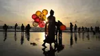 Seorang wanita menjual balon di Pantai Juhu, Mumbai, India, Selasa (24/8/2021). India mencatat penambahan 14.419 kasus positif COVID-19 pada 24 Agustus 2021. (AP Photo/Rafiq Maqbool)