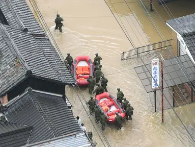Pasukan Bela Diri Jepang menyusuri banjir saat melakukan penyelamatan di Takeo, Prefektur Saga, Jepang, Rabu (28/8/2019). Otoritas Jepang merilis perintah evakuasi bagi 240 ribu warga di kawasan barat daya yang diprediksi akan diterjang banjir dan tanah longsor. (Kyodo News via AP)