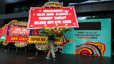 Seorang petugas membawa karangan bunga di kantor PSSI yang terletak di GBK Arena, Senayan, Jakarta, Kamis (30/03/2023) sebagai respon pembatalan Indonesia sebagai tuan rumah Piala Dunia U-20 2023 oleh FIFA. (Bola.com/Bagaskara Lazuardi)