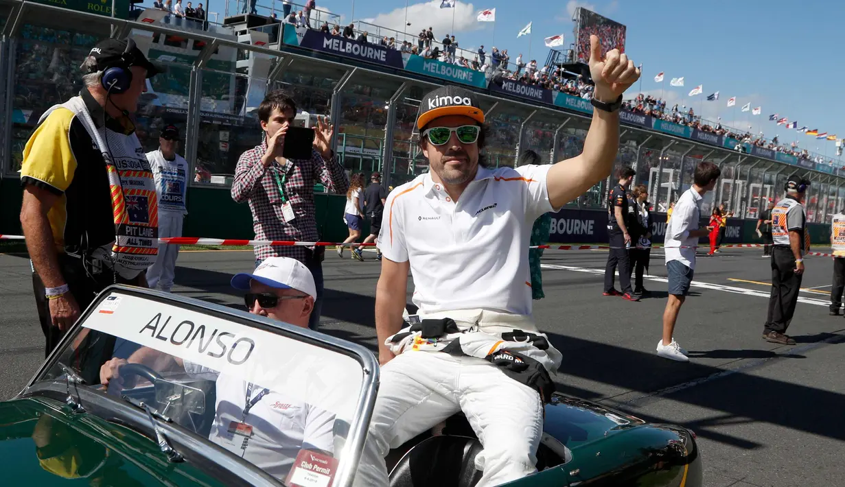 Pembalap F1 tim McLaren, Fernando Alonso duduk di atas mobil saat mengikuti parade jelang balapan pertama musim ini di GP F1 Australia di Melbourne, Australia, (25/3). Alonso akan memulai balapan dari posisi ke-11. (AP Photo/Asanka Brendon Ratnayake)