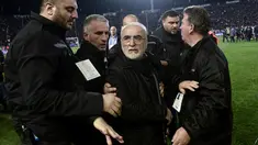 Presiden PAOK Ivan Savvidis diamankan petugas setelah turun ke lapangan dengan pistol di pinggangnya saat Liga Super Yunani di Stadion Toumbas, Minggu (11/3). Laga yang mempertemukan PAOK dengan AEK Athens terpaksa harus ditunda. (SAKIS MITROLIDIS/AFP)