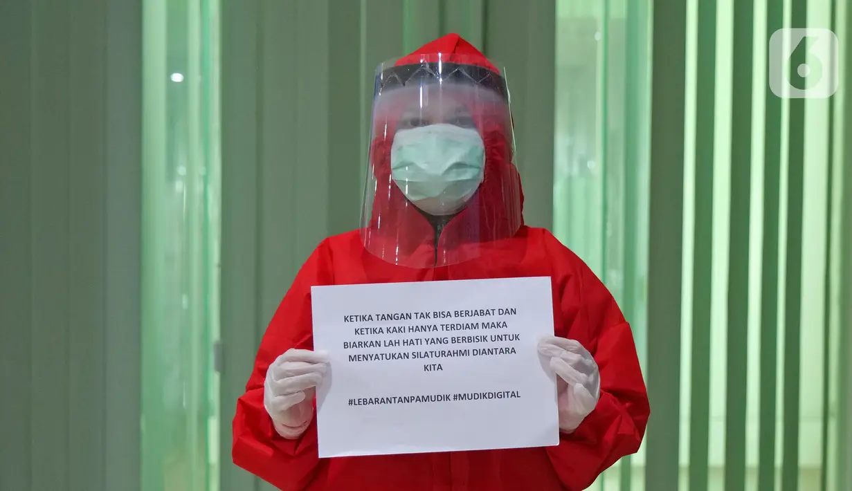 Perawat Risa Nur (24) menyampaikan pesan lewat sebuah tulisan saat di RSUD Pasar Minggu, Jakarta, Jumat (22/5/2020). Sejumlah garda terdepan Covid-19 menyampaikan pesan lewat sebuah tulisan. (Liputan6.com/Herman Zakharia)