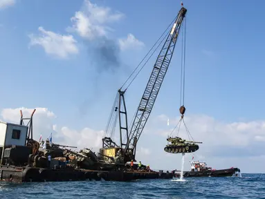 Aktivis lingkungan menenggelamkan sebuah tank lama ke dasar Laut Mediterania di lepas pantai kota pelabuhan Sidon, Lebanon, Sabtu (28/7). Mereka menenggelamkan 10 tank lama yang disediakan oleh Angkatan Bersenjata Lebanon. (AFP / Mahmoud ZAYYAT)