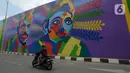 Pengendara motor melintas di Flyover 'Gaplek' Martadinata yang dipercantik dengan lukisan mural di Tangerang Selatan, Jumat (9/4/2021). Seni mural ini untuk memperindah suasana jalan kota. (merdeka.com/Imam Buhori)