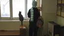Pengunjung berdiri di samping seekor kucing yang memandang ke luar jendela, di Museum Kucing Persia di Teheran, Iran, pada 5 Desember 2021. Didirikan di sebuah rumah tua pada tahun 2020, Museum Kucing Persia ini berawal dari kafe serba guna dan pameran kucing. (AP Photo/Vahid Salemi)