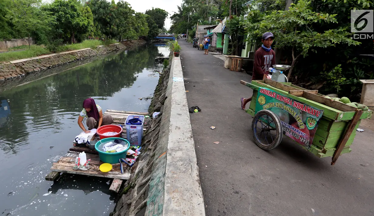 Warga memanfaatkan aliran Kali Maja untuk mencuci pakaian, Jakarta, Selasa (7/11). Warga dikawasan tersebut terpaksa memanfaatkan air kali untuk mencuci dikarenakan air di rumah mereka keruh dan asin. (Liputan6.com/JohanTallo)