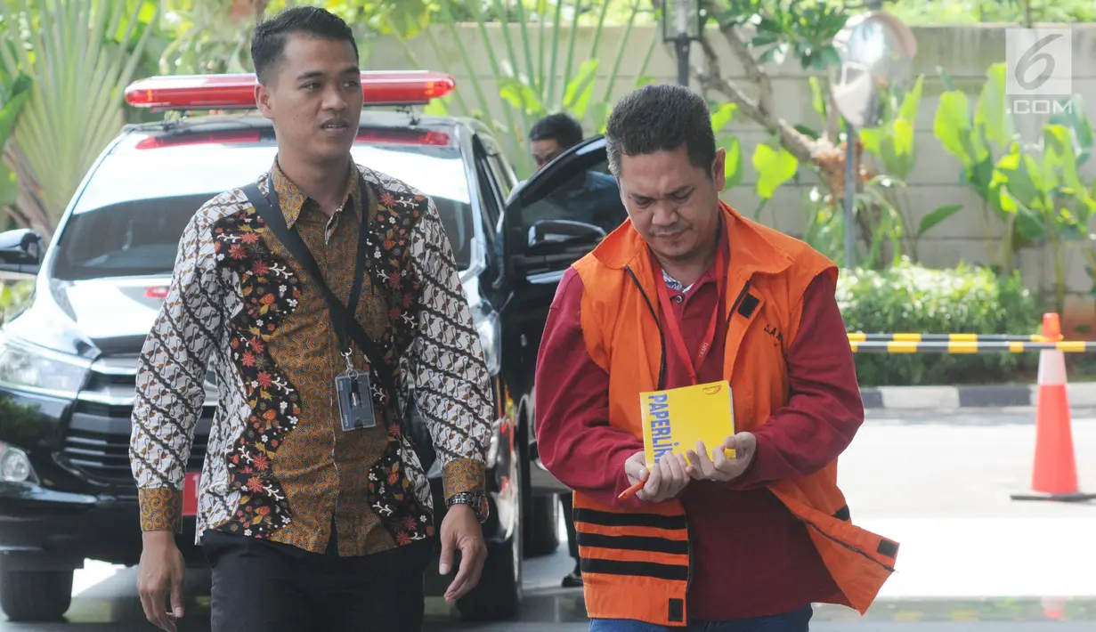 Kepala Kantor Imigrasi Kelas I Mataram, Kurniadie dikawal petugas bersiap menjalani pemeriksaan di Gedung KPK, Jakarta, Selasa (18/6/2019). Kurniadie diperiksa terkait dugaan suap penyalahgunaan izin tinggal warga negara asing di lingkungan kantor Imigrasi NTB Tahun 2019. (merdeka.com/Dwi Narwoko)