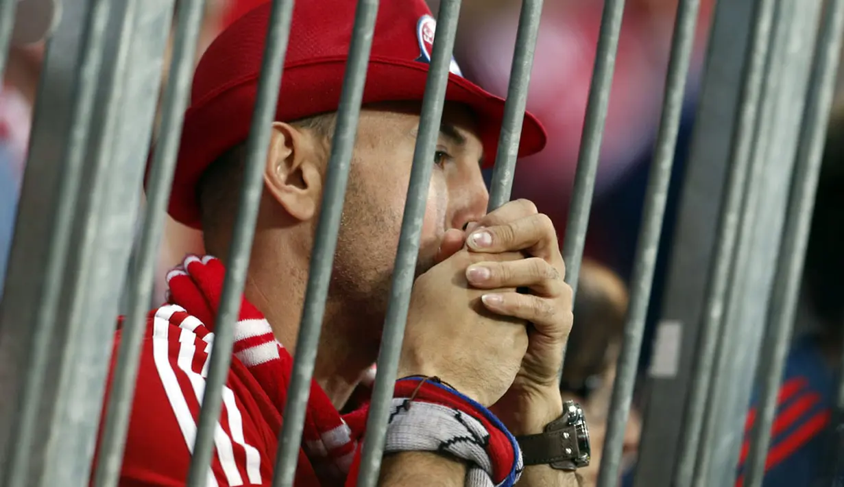 Dari balik pagar pembatas, salah satu fans Bayern Munich menyaksikan tim favoritnya dipecundangi Real Madrid 0-4 di Allianz Arena, (30/4/2014). (REUTERS/Michaela Rehle)