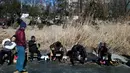 Sejumlah warga bersiap bermain ice skating di sungai yang membeku di Beijing, China (21/1). Akibat membeku, Sungai ini menjadi objek wisata dadakan yang banyak diminati wisatawan. (AFP/Fred Dufour)