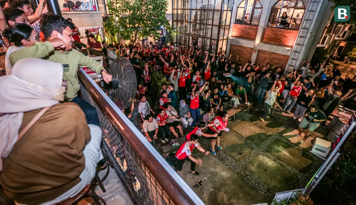 Pendukung Arsenal yang tergabung ke dalam AIS (Arsenal Indonesia Supporters) merayakan gol ketiga timnya ke gawang Tottenham Hotspur yang dicetak oleh Kai Havertz saat Roaring Night Liga Inggris di The Ground at Nipah, Jakarta Selatan, Minggu (28/04/2024). (Bola.com/Bagaskara Lazuardi)