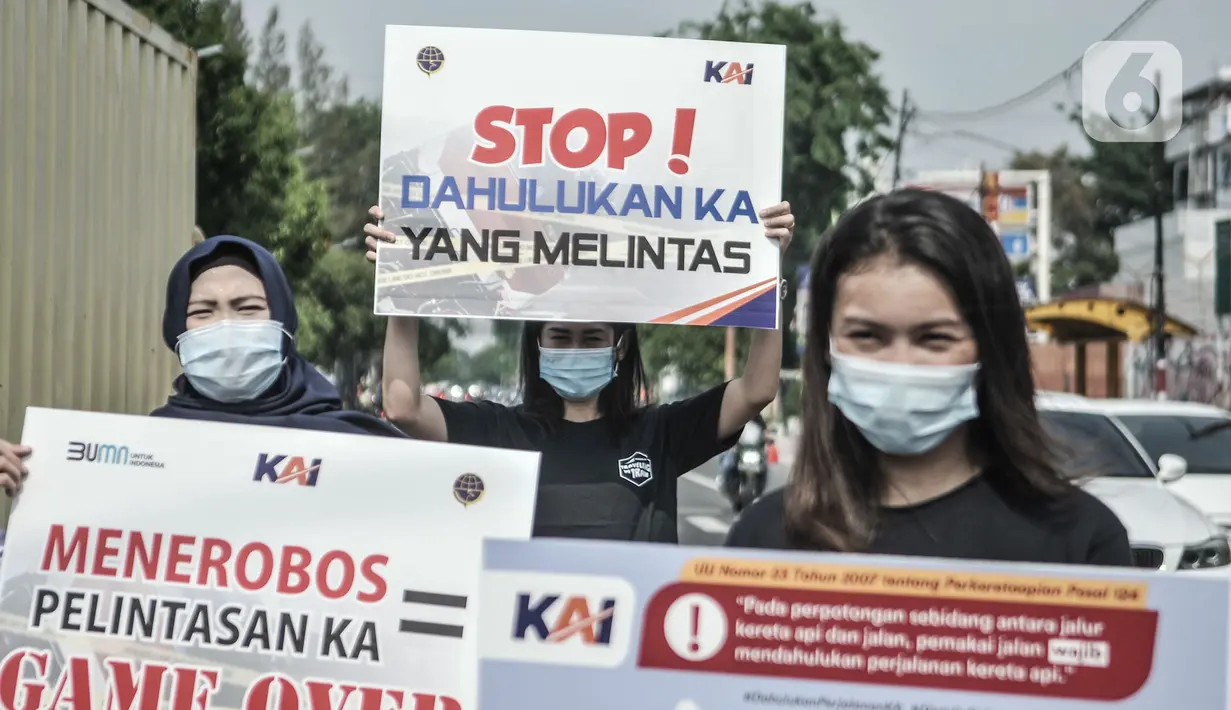 Petugas PT KAI saat sosialisasi keselamatan di perlintasan kereta api sebidang, Kemayoran, Jakarta, Rabu (14/10/2020). PT KAI Daop 1 menggelar sosialisasi dan aksi teatrikal dalam rangka meningkatkan kesadaran pengendara saat melintasi perlintasan sebidang. (merdeka.com/Iqbal Nugroho)