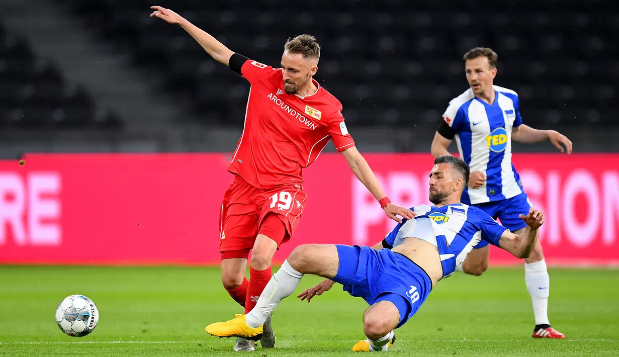 Penyerang Hertha Berlin, Vedad Ibisevic, berebut bola dengan bek Union Berlin, Florian Huebner, pada laga lanjutan Bundesliga di Stadion Olimpiade, Berlin, Sabtu (23/5/2020) dini hari WIB. Hertha Berlin menang 4-0 atas Union Berlin. (AFP/Stuart Franklin/Pool)