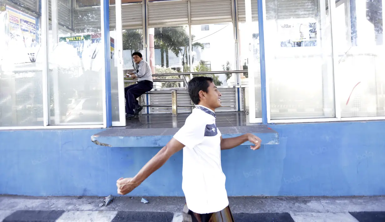Samsul Arif melintas dekat halte bus usai mengikuti salat berjamaah bersama rekan-rekannya  di Masjid Nurul Huda,  Sidoarjo, Jawa Timur, Sabtu (11/6/2016). (Bola.com/Nicklas Hanoatubun)
