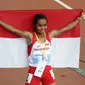 Atlet putri Indonesia, Triyaningsih membentangkan sang Merah Putih saat melakukan perayaan kemenangannya di nomor 10.000 M di National Stadium Singapura, (11/6/2015). Triyaningsih mencatatkan waktu 33 menit 44,53 detik. (Liputan6.com/Helmi Fithriansyah)