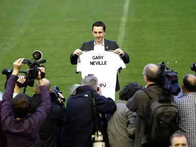 Mantan Pemain Manchester United, Gary Neville berfoto dengan Jersey Valencia bertuliskan namanya di Stadion Mestalla, Kamis (3/12/2015). Gary didaulat sebagai pelatih baru Valencia. (AFP Photo/Jose Jordan)